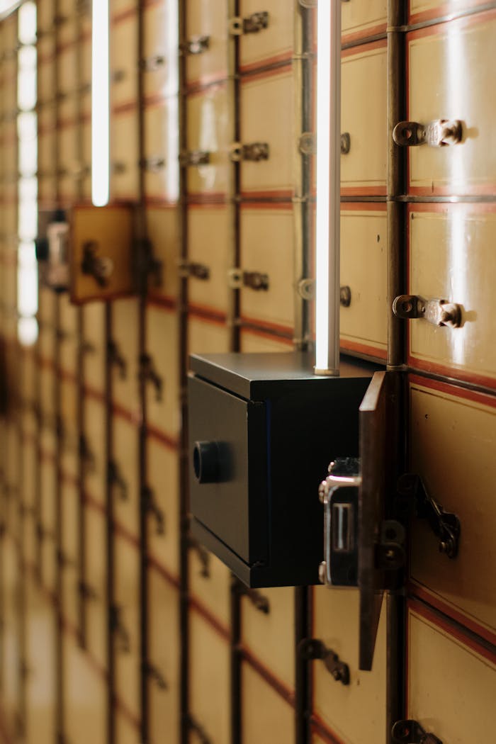 services-03 Close-up of vintage safety deposit boxes with one open, revealing secure interiors.