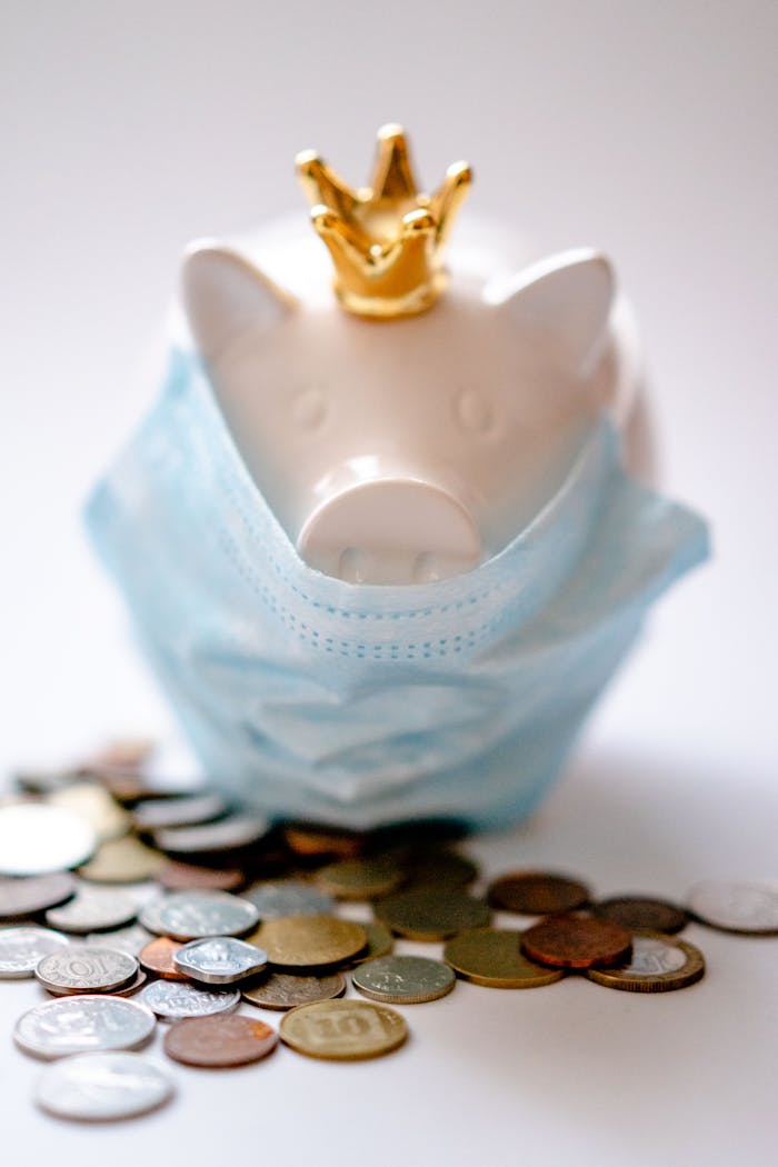 team-01 Money box with crown and protective mask among coins representing concept of saving money during COVID pandemic